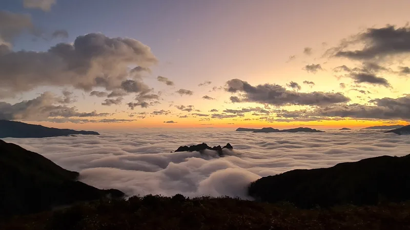 A sea of clouds blankets the mountain valleys of Lai Chau under a glowing sunrise sky.