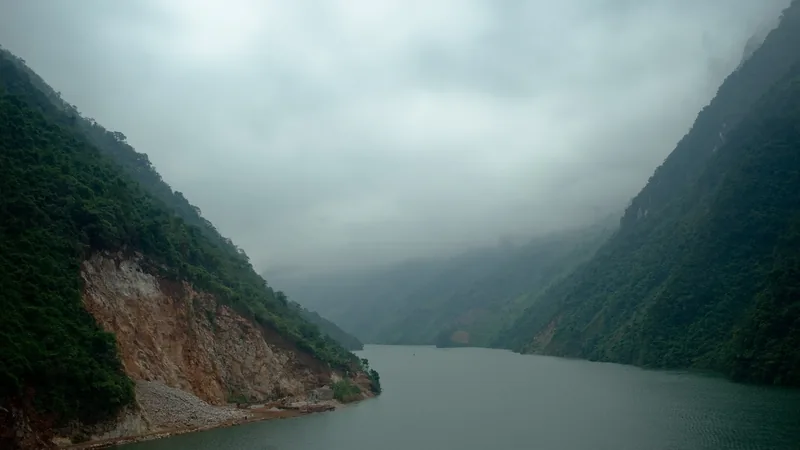 Misty mountains rise steeply along the Da River in Lai Chau province.