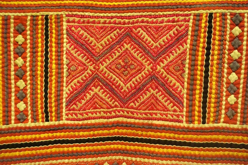 Close-up of a colorful Hmong embroidered apron with geometric diamond patterns, Lai Chau, Vietnam.