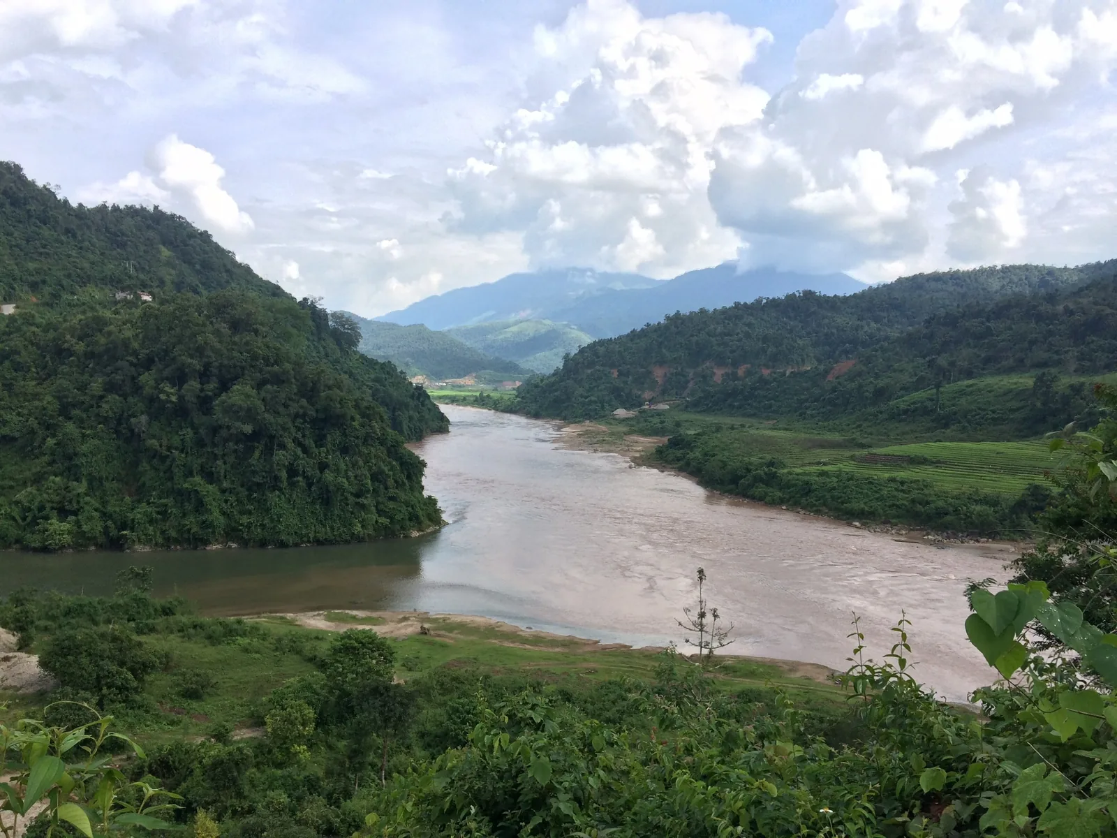 A muddy river winds through green mountains near Muong Te in Lai Chau, Vietnam.